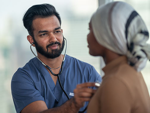 male doctor listening to patient's heart beat