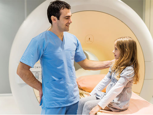 Radiology technician talking to a young patient before she undergoes an MRI